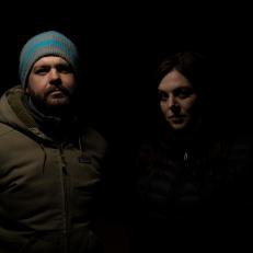 Hosts Jack Osbourne and Katrina Weidman posing for a photo in front of a black background. As seen on Travel Channel's Portals To Hell.