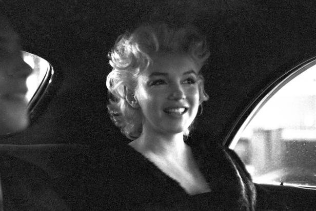 73996554 NEW YORK - MARCH 30: Actress Marilyn Monroe rides in the back of a car with Dick Shepherd on March 30, 1955 in New York City, New York. (Photo by Ed Feingersh/Michael Ochs Archives/Getty Images)
